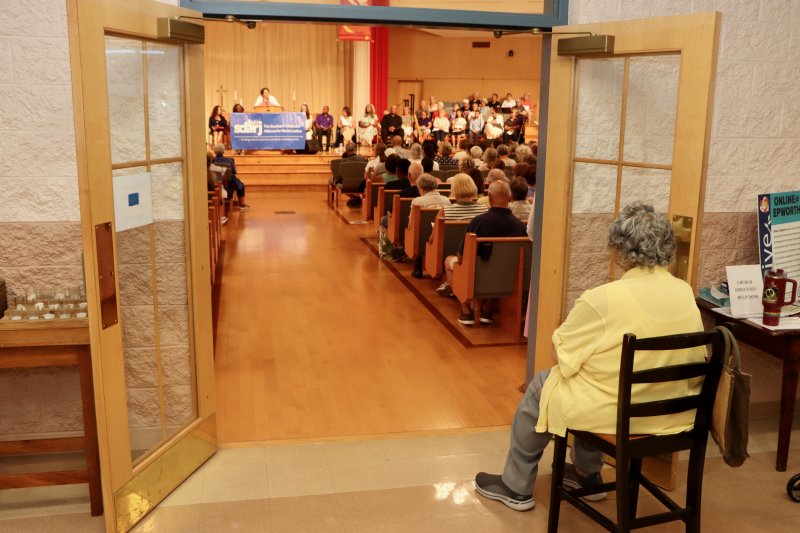 Charlotte King, founder of the Southern Delaware Alliance for Racial Justice, watches the celebration from the lobby. SDARJ hosted the event. The standing room-only crowd made the sanctuary very warm. The speakers urged people to turn up the heat against racial injustice.